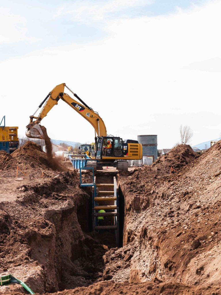 Gelber Bagger beim Erdaushub auf Baustelle